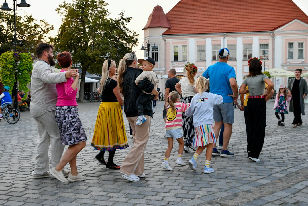 Group of residents gathered in a town square in a small Polish community